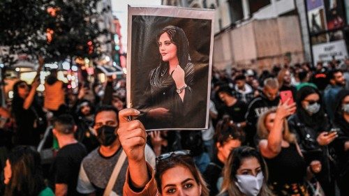 (FILES) In this file photo taken on September 20, 2022 a protester holds a portrait of Mahsa Amini  ...