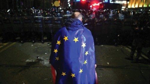 A demonstrator wears a European Union flag during a protest against a draft law on 'foreign agents', ...