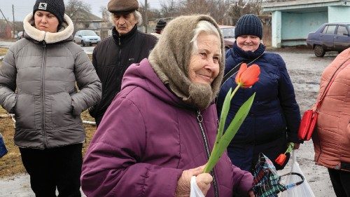 epa10509680 A local woman carries humanitarian aid and flowers received from Ukrainian volunteers on ...