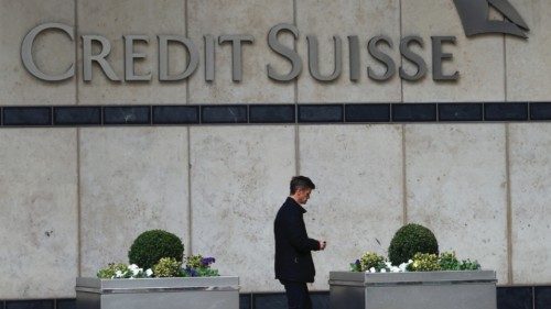 A man walks past the Credit Suisse office in Canary Wharf in London, Britain, March 16, 2023. ...