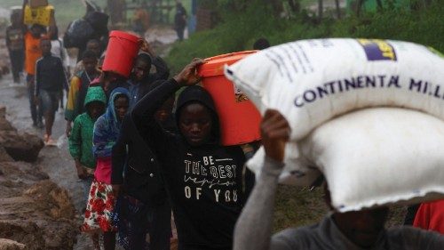 Locals in the Chiradzulu district walk with their salvaged possessions to a safer grounds after ...