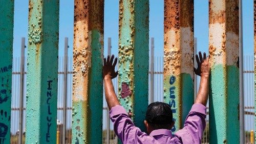 TOPSHOT - A man prays at the border fence during the 'Remembering our Fallen Exile Deported ...