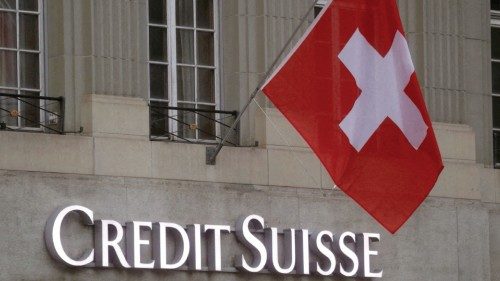 FILE PHOTO: Switzerland's national flag flies above a logo of Swiss bank Credit Suisse in front of a ...