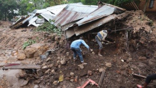 People dig for their belongings after their home was destroyed during a landslide in Chilobwe, ...