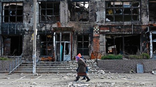 TOPSHOT - Local residents walks in front of a destroyed store in the Tsirkuny village, Kharkiv ...