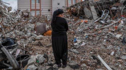A local resident stands among the debris as she searches for her belongings in Adiyaman on March 24, ...