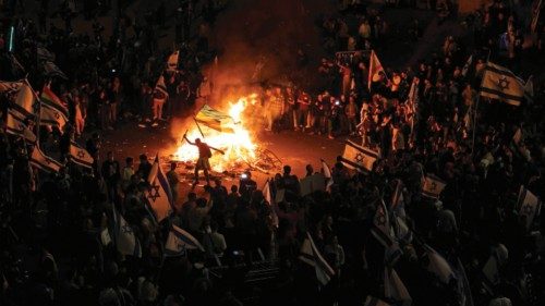 Protesters block a road and hold national flags as they gather around a bonfire during a rally ...
