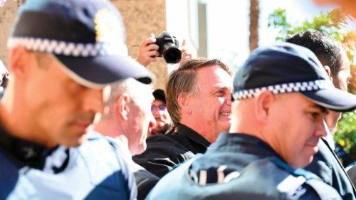 Former Brazilian president Jair Bolsonaro, surrounded by police officers, greets supporters at the ...