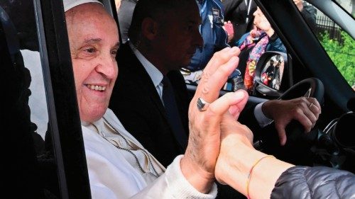 Pope Francis shakes a person's hand from his car as he leaves the Gemelli hospital on April 1, 2023 ...