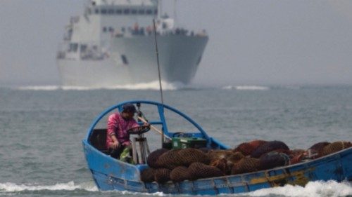 A fishing boat sails past a Chinese warship during a military drill off the Chinese coast near ...