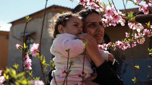 Rokan Youssef poses as she carries her daughter in Jinwar, an all-women village, in Al-Darbasiyah ...