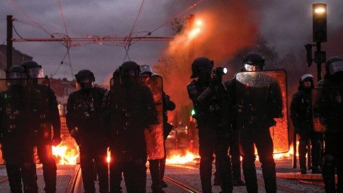 TOPSHOT - French anti-riot police officers stand in front of waste bins on fire during clashes with ...