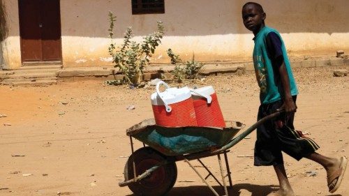 FILE PHOTO: A person pushes a wheelbarrow with water containers during clashes between the ...