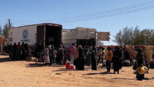 Sudanese families prepare to ride on trucks while on their way to Egypt through the Qustul border, ...