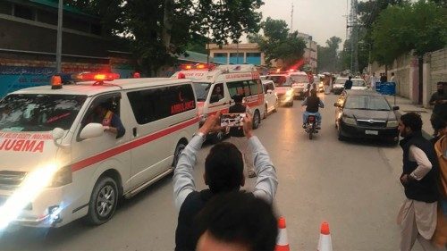 Ambulances carry victims' coffins of those who were killed in the sectarian violence inside a ...