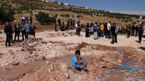Palestinians gather at the site where Israeli army bulldozers demolished a school that they said was ...