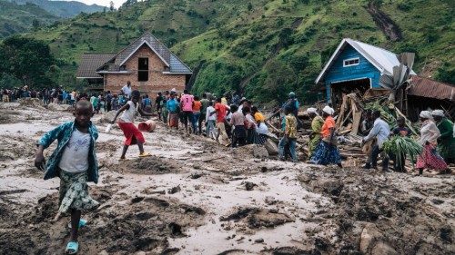 Residents of Nyamukubi walk through the rubble after heavy flooding in eastern Democratic Republic ...