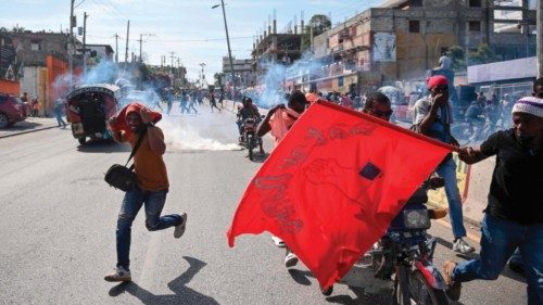 Workers flee teargas fired by police as they demonstrate to demand better wages and working ...