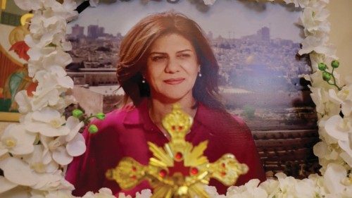 A portrait of slain Al-Jazeera journalist Shireen Abu Akleh is framed with flowers with a cross in ...