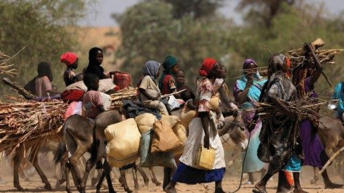 FILE PHOTO: Sudanese refugees who fled the violence in Sudan's Darfur region and newly arrived ride ...