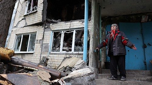 TOPSHOT - Local resident Ludmyla, 76, stands in front of a heavily damaged residential building in ...