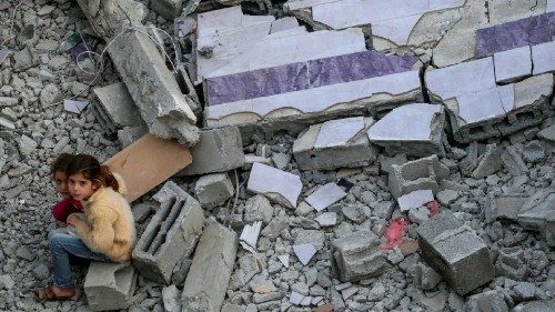 epa10628570 Two Palestinian sisters from the Abu-Nabhan family sit near the rubble of their ...