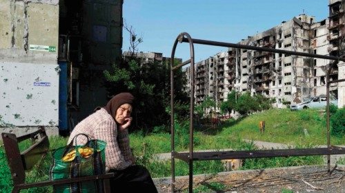 (FILES) In this file photo taken on May 31, 2022 an elderly woman sits on a bench in a yard of ...