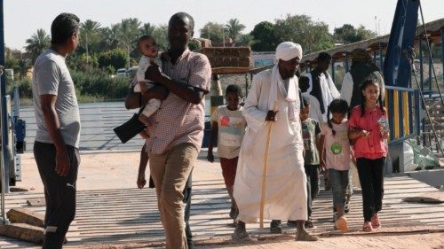 epa10639980 Sudanese people disembark after traversing the Nile River on a ferry after crossing the ...