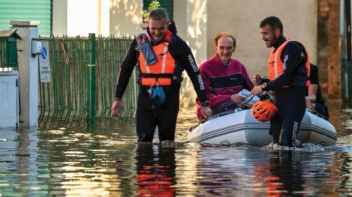 Rescuers from the Italian Coast Guards evacuate a resident in a dinghy across a flooded street on ...