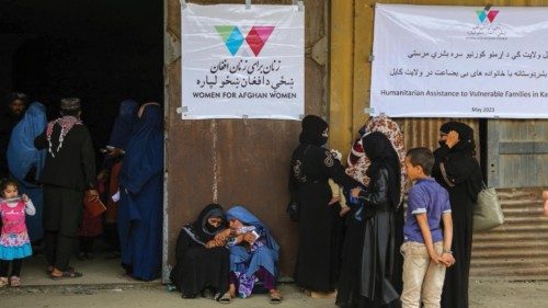 epa10647814 Afghans wait to receive rations distributed by the Directorate of Refugees in Kabul, ...