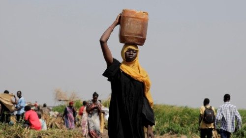 epa10629419 A South Sudanese woman carries a bucket of water from the Nile river in the vicinity of ...