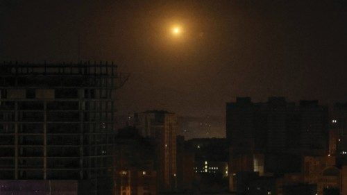 An explosion of a drone is seen in the sky over the city during a Russian drone strike, amid ...