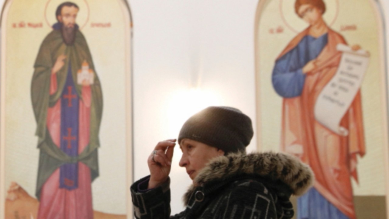 A believer attends a liturgy at the Ukrainian Catholic Cathedral of the Resurrection of Christ in ...