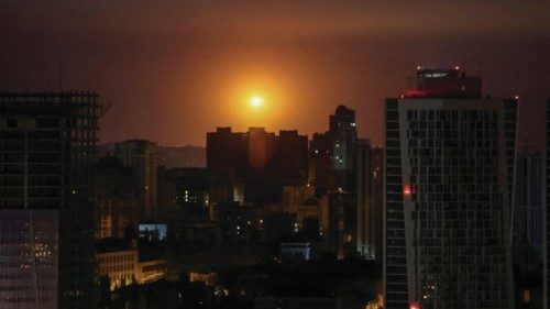 An explosion is seen in the sky over the city during a Russian drone and missile strike, amid ...