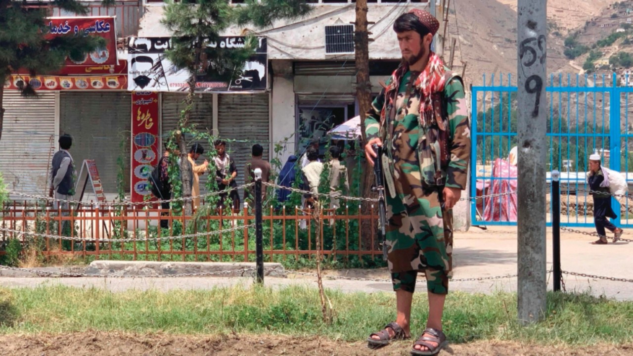 A member of Taliban stands guard near the site of a suicide attack in Faizabad district of ...