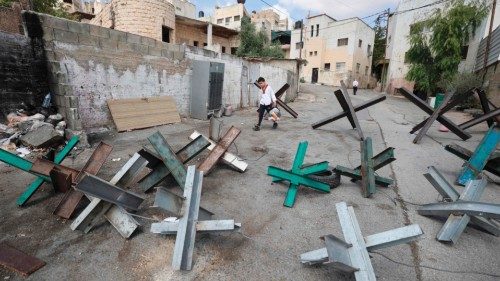 TOPSHOT - A boy navigates through barricades set up by Palestinians in an effort to prevent Israeli ...