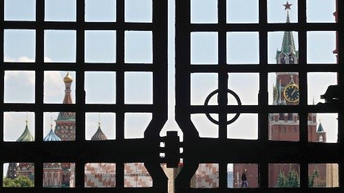 epa10710732 A person (C-R, rear), seen through a gate, walks in the blocked Red Square in Moscow, ...