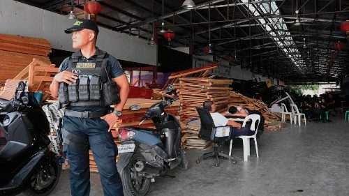 A policeman stands guard inside a compound, where police raided buildings in Metro Manila on June ...