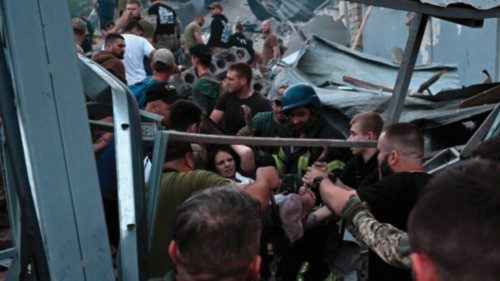 TOPSHOT - Rescuers and volunteers carry a rescued woman from the rubble after Russian missile strike ...
