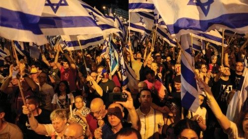 Demonstrators wave national flags during a rally to protest the Israeli government's judicial ...