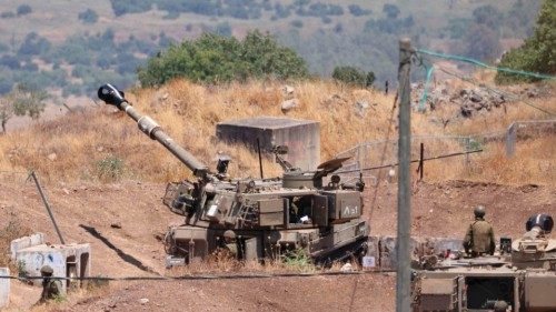 Israeli soldiers stand near an army tank on the outskirts of Kiryat Shmona near Israel's border with ...