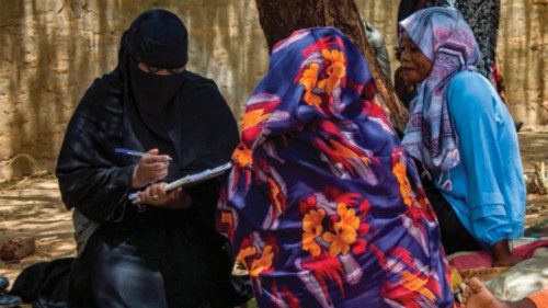 Women are interviewed under the shade of a tree outside at a camp for the internally displaced in ...