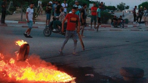 Tunisian youths block the road to migrants as tensions rose in Sfax after the burial of a young ...