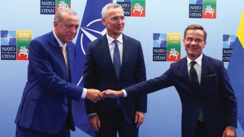 Turkish President Tayyip Erdogan and Swedish Prime Minister Ulf Kristersson shake hands next to NATO ...