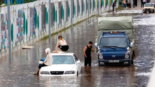 People make their way out of a flooded street after sustained rains in Ulaanbaatar, the capital of ...