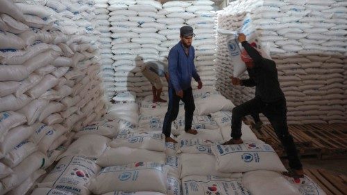Workers unload bags of aid at a warehouse near the Syrian Bab al-Hawa border crossing with Turkey, ...