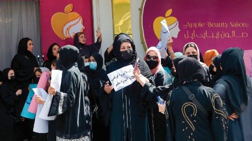 Afghan burqa-clad women stage a protest for their rights at a beauty salon in the Shahr-e-Naw area ...