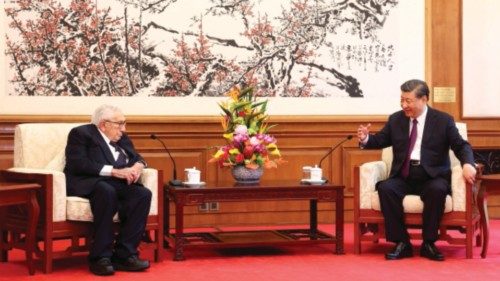 China's President Xi Jinping (R) speaks with former US secretary of state Henry Kissinger during a ...