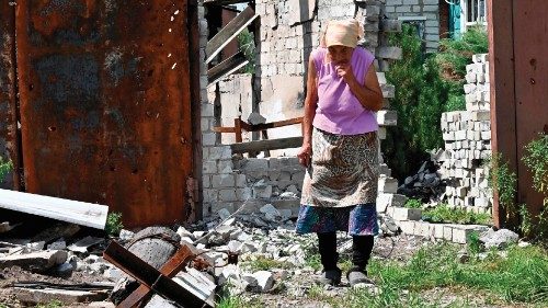 TOPSHOT - Local resident Maria Laptykova, 87, reacts as she walks outside her house destroyed by ...
