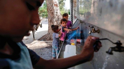 Palestinian children fill up water bottles from a cooler at a Bedouin village near Beit Lahia in the ...